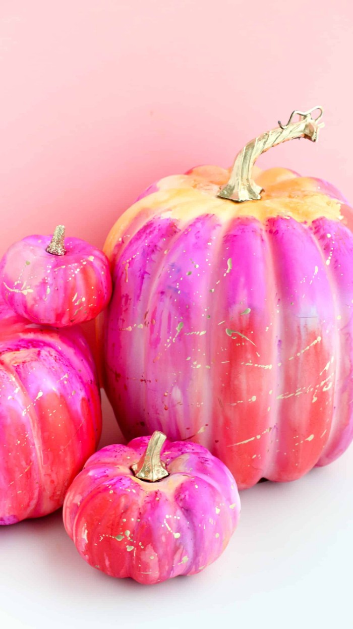 purple and fuchsia pink, red and white and blue paint, covering four pumpkins, in different sizes, halloween pumpkin decorations, white and pale pink background