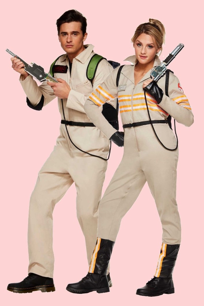 matching beige overalls, with white and orange stripes, worn by a man and woman, holding gun-like weapon props, dynamic duo ideas, ghostbusters themed halloween