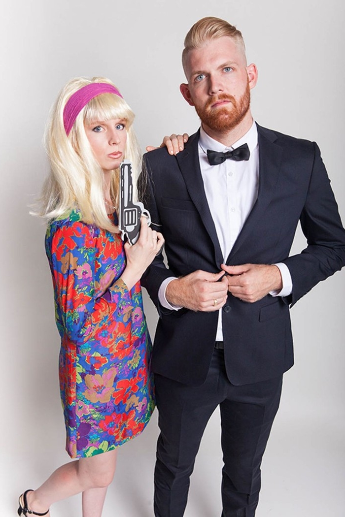 bearded man with blonde hair slicked back, dressed in a tuxedo, woman in a blonde wig, wearing a 1960s floral dress, and holding a faux gun, couple costume ideas, james bond and bond girl