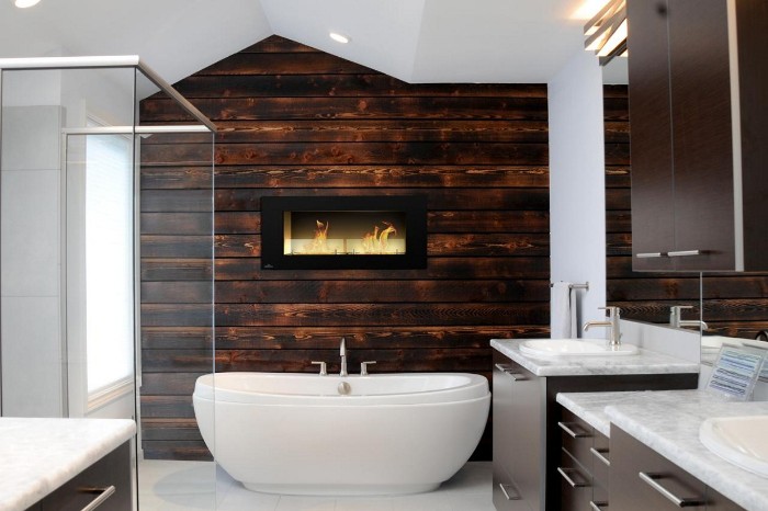 wooden bathroom accent wall, in dark brown, containing a small fireplace, in a white room, with a glass shower cabin, and a white bathtub