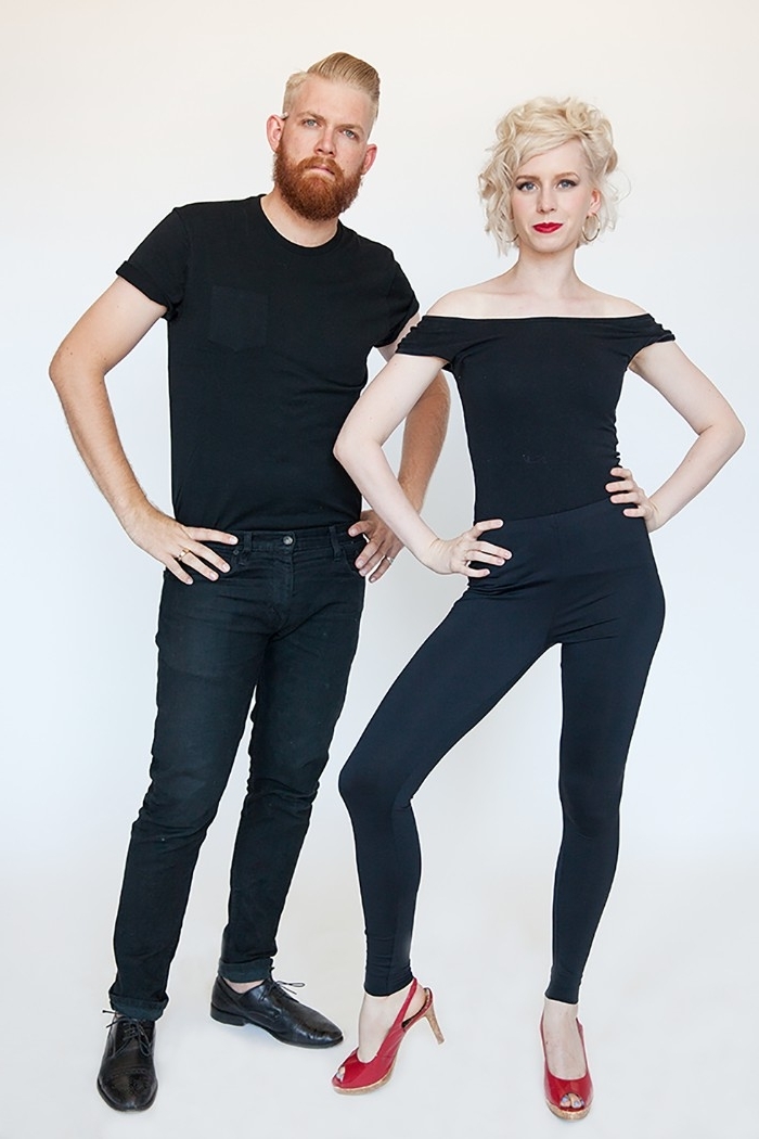 ginger man with a beard, dressed in dark jeans, and a black t-shirt, standing near a blonde woman, wearing black leggings, an off-the-shoulder top, and red high heels, quick halloween costumes, inspired by grease