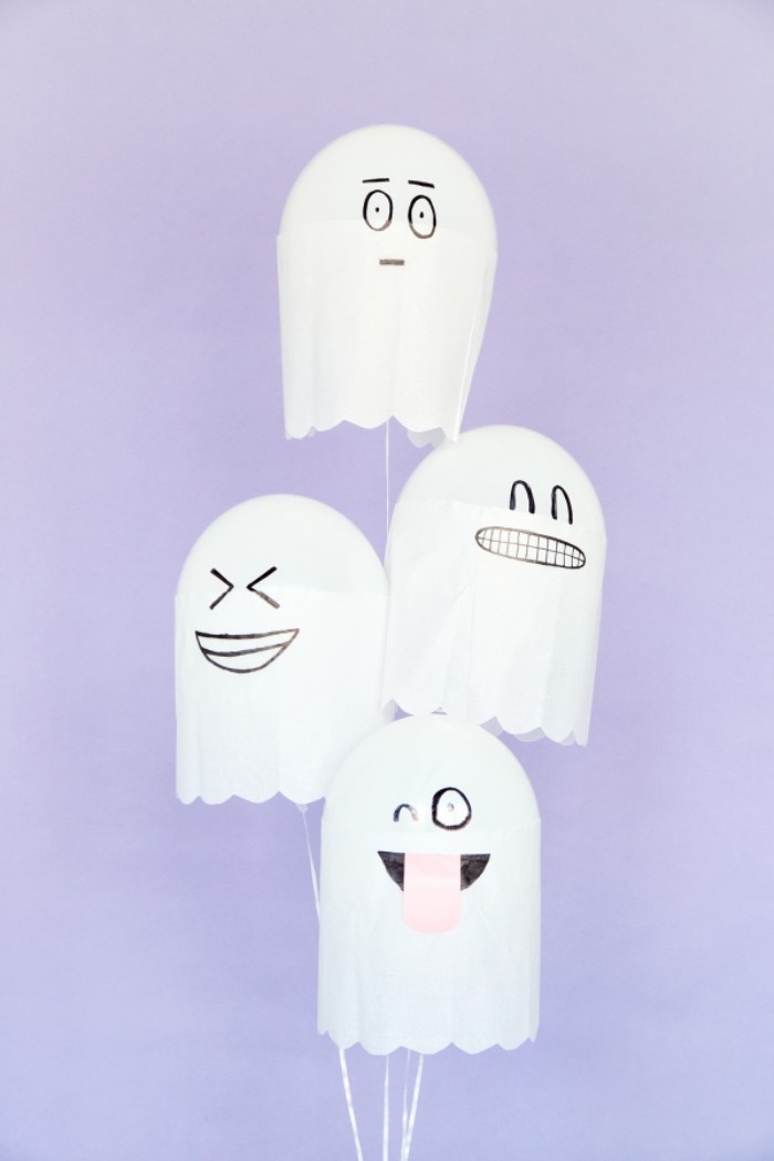 bunch of white balloons, decorated with white paper, to look like ghosts, with silly hand-drawn faces