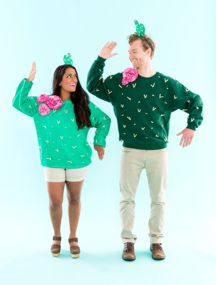 funny couple halloween costumes, smiling man and woman, dressed in green jumpers, decorated like cacti, small cactus hat, on both of their heads