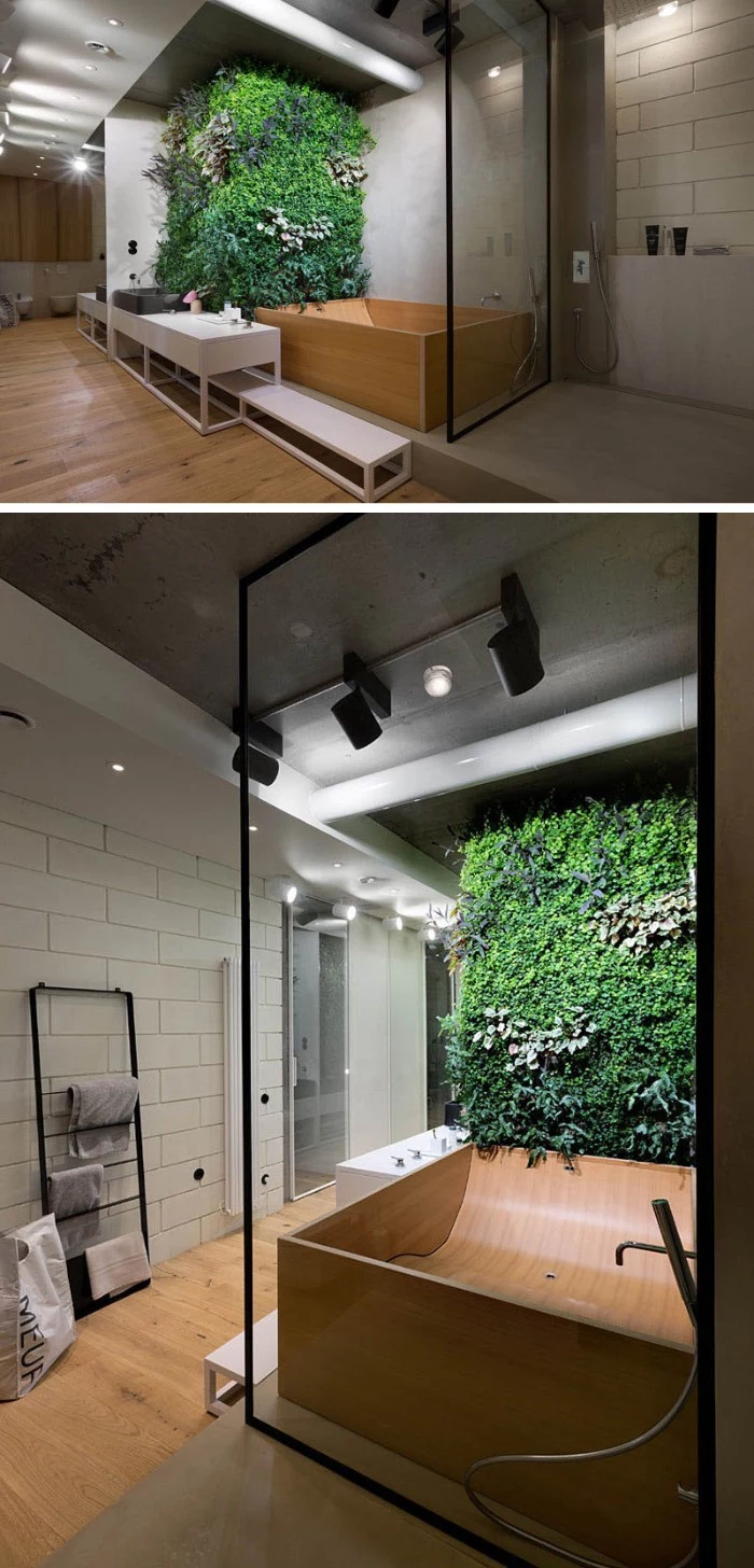 wall covered in green plants, near a bathtub, made from pale beige wood, inside a room with white tiled walls, and a laminate floor, master bath remodel