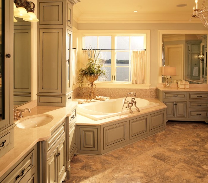 vintage-style bathroom, with creamy grey furniture, white elevated bathtub, brownish-grey floor, and a window with white blinds