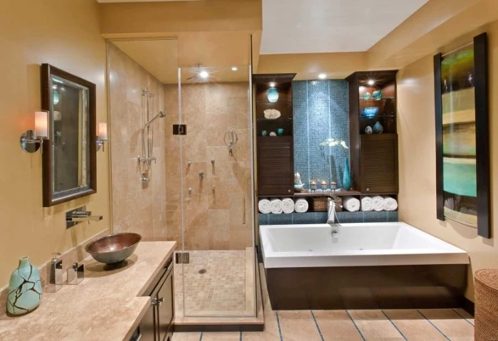 blue and beige, and dark brown bathroom, containing a large square tub, and a glass shower cabin