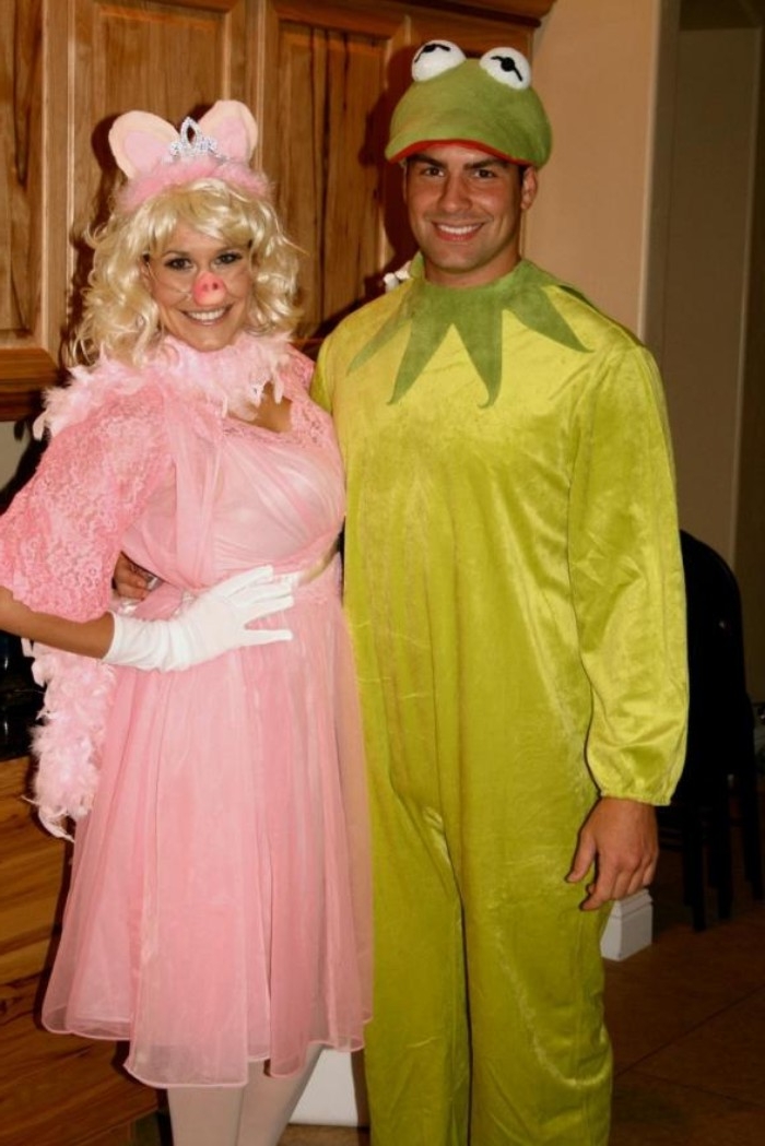 kermit the frog, and miss piggy, costumes inspired by the muppet show, woman dressed in pink, with a curly blonde wig, and a pig mask, man in a frog onesie