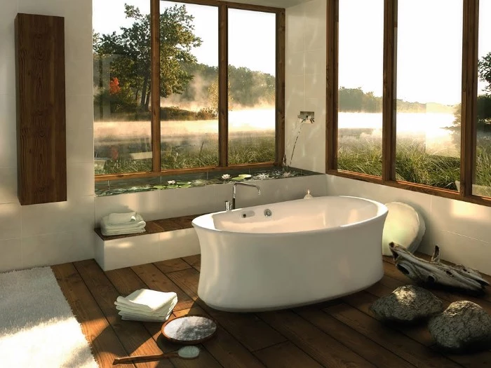 smooth white bathtub, inside a room with several large windows, brown wooden floor, and a pale rug, bathroom remodel pictures, natural pieces of wood used as decorations