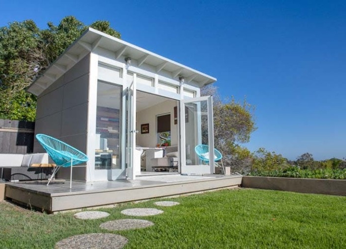 home office shed, with double doors made of glass, and two big windows, garden shed ideas, two modern teal chairs nearby