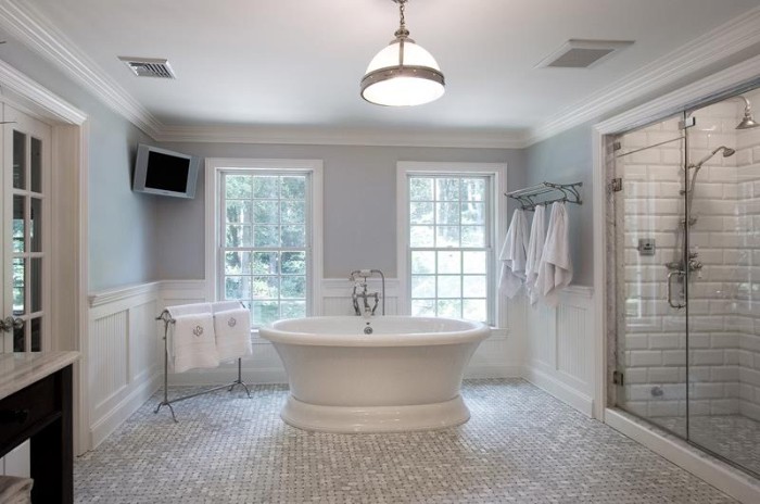 light grey walls, in a room with white paneling, and mosaic tiles on the floor, glass shower cabin, and a white, vintage style tub