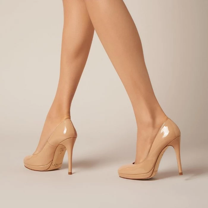 high-heeled pumps, in nude beige color, worn by a pair of pale, slim female legs, what is a capsule wardrobe, essential shoes for women