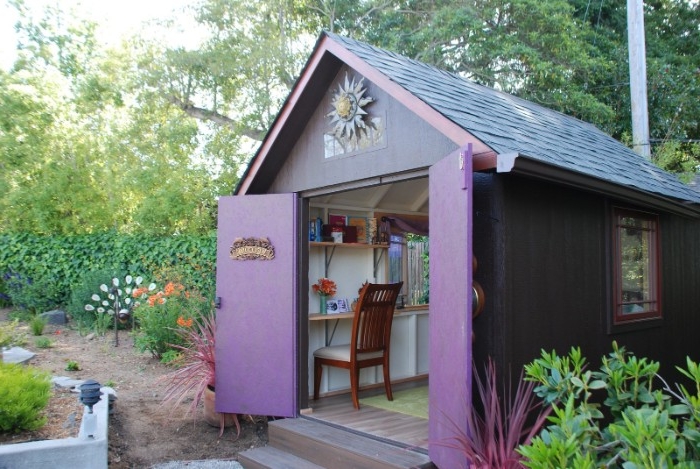 purple hut with blue roof, garden shed ideas, open double doors reveal a wooden chair, and several shelves inside