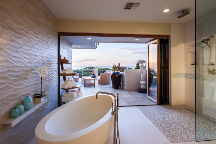 egg-shaped bathtub in white, in a room with pale beige walls, white shelf with an orchid, and three small teal pots, spa like bathrooms, large open window, overlooking a terrace