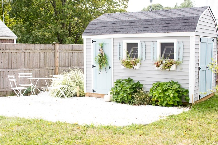 garden shed ideas, structure in creamy light grey, and pale blue, with dark grey roof, two open windows, and two visible doors