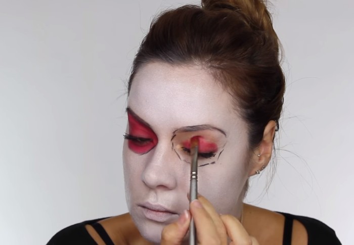 putting pink eye shadow, on the eyelids of a young woman, with face covered in white paint, skeleton face paint, step by step tutorial