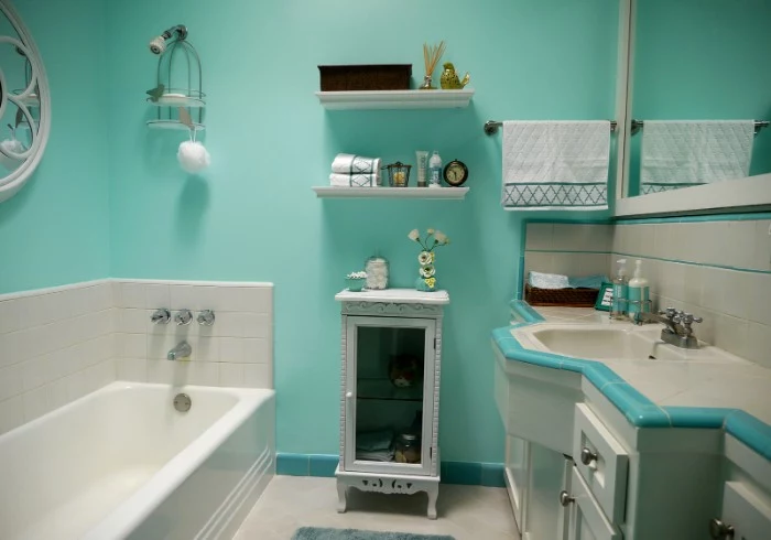 retro-style bathroom, with robin's egg blue walls, a white bathtub, and an antique white cupboard