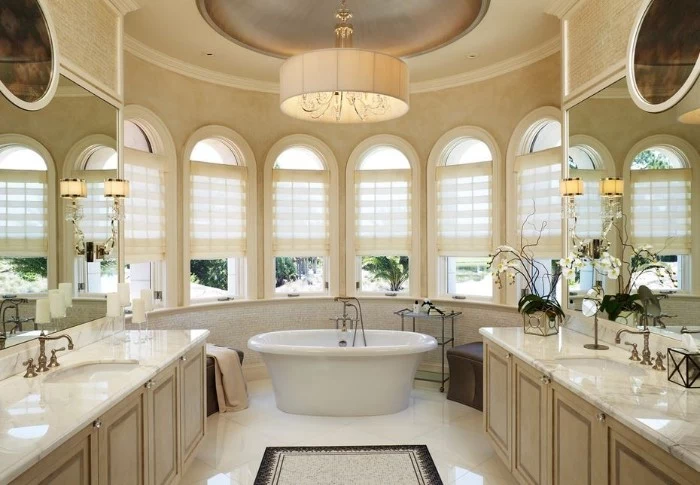 six windows inside a semi-round bathroom, with a cream, beige and white color palette, vintage style bathtub in white