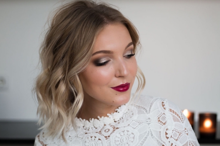 ombre shoulder length hair, worn by a smiling woman, burgundy lipstick and silver and grey smokey eye shadow, eye makeup for red lips, white lace top