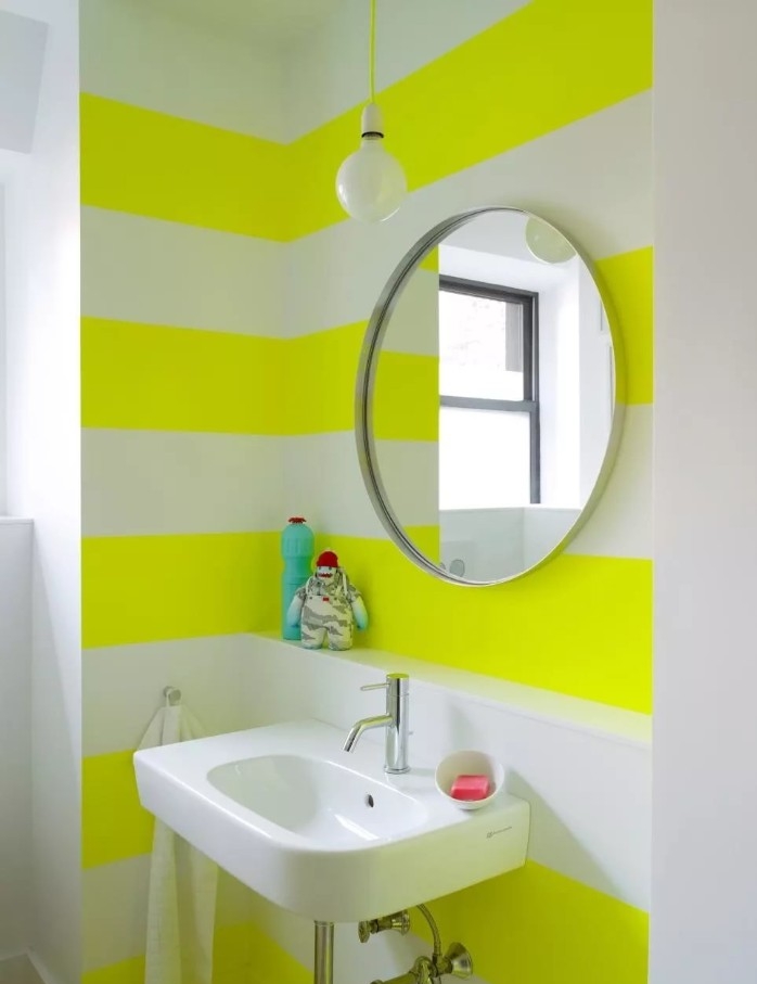 best paint for bathrooms, white and yellow stripes, on a bathroom wall, decorated with a round mirror