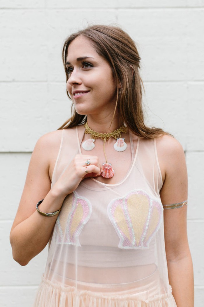 couple costume ideas, smiling brunette woman, dressed like a mermaid, in a sheer pale pink midi dress, with shell details