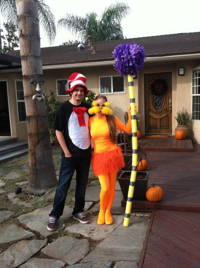 dr seuss character costumes, a man dressed like the cat in the hat, and a woman dressed like the lorax, standing in front of a house, funny couple halloween costumes