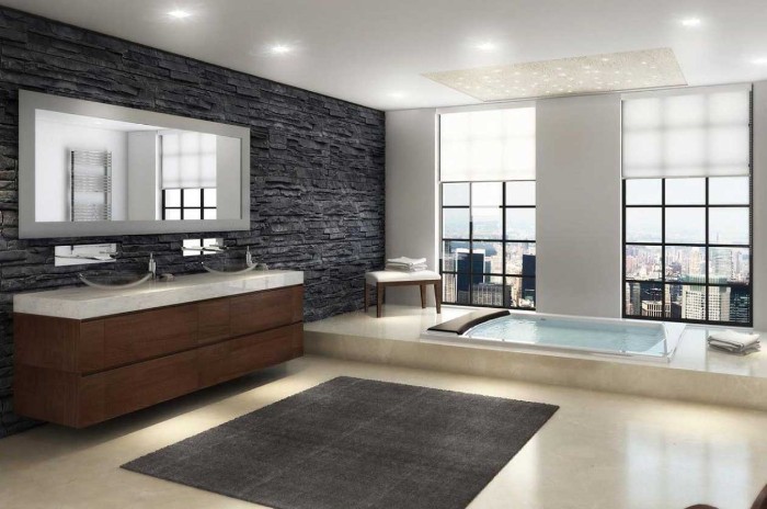 coarse natural stone tiles in pewter grey, decorating the wall of a bright room, with two large windows, bath remodel ideas, inbuilt rectangular tub, smooth pale beige floor