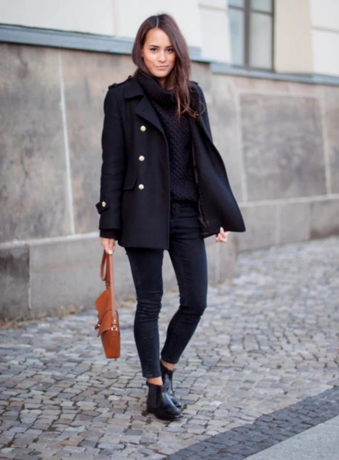 military woolen coat in black, worn by a smiling, young brunette woman, in dark grey skinny jeans