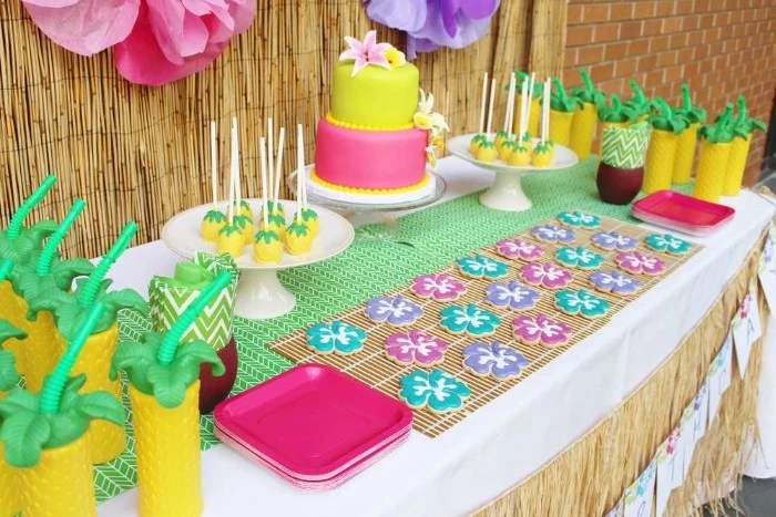 lime green and hot pink cake, decorated with realistic lilies, made from fondant, on a colorful table, with flower-shaped cookies, drinks and sweets shaped like pineapples, 50th birthday colors, hawaiian-themed bash