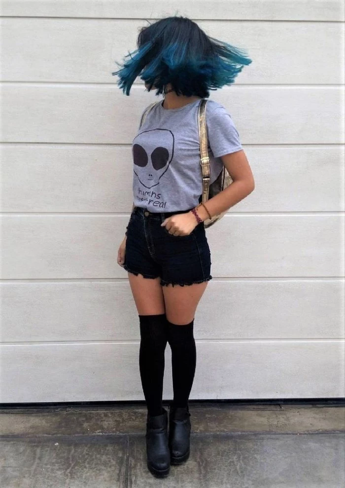 shoulder length ombre hair, in dark and light blue, on a twirling girl, dressed in black cutoff shorts, black over the knee socks, and ankle boots, and a grey t-shirt, featuring an alien print, grunge girl ideas, shiny gold backpack