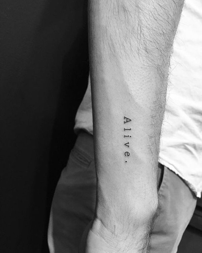 letters with clear and sharp design, spelling the word alive, tattooed on a man's arm, lower arm tattoos, seen in close up