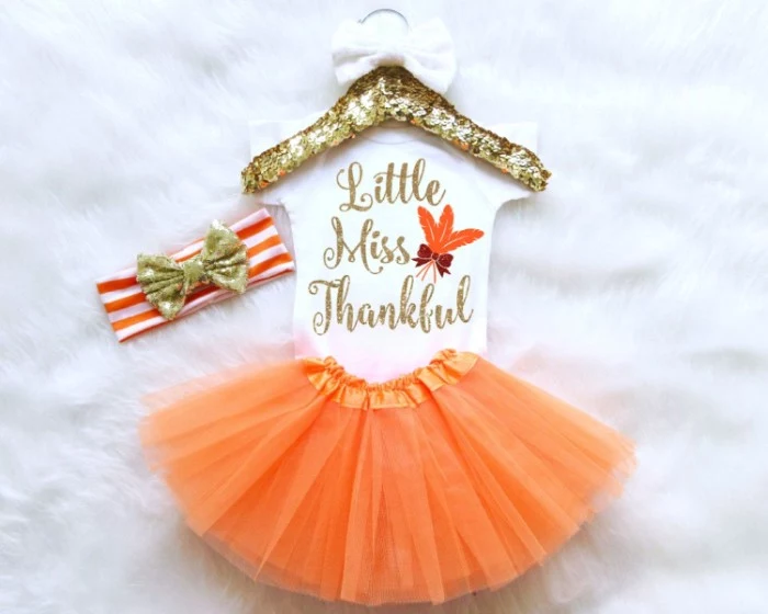 little miss thankful, written in gold, on a white onesie, with orange and brown motifs, tutu skirt in orange, and a white and orange striped headband, with a sparkly gold bow, baby girl thanksgiving outfit