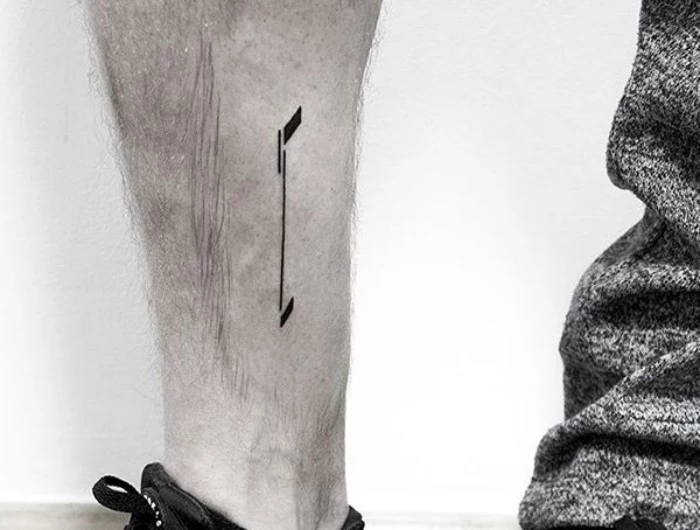 half of an arrow, simple and minimalistic design, tattooed in black ink, on a person's lower leg, meaningful tattoo ideas, symbolizing a fresh start, looking at the future