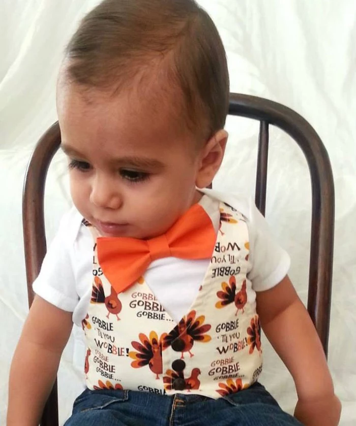 vest in white, with a cartoon turkey pattern, worn with an orange bow tie, over a white t-shirt, baby's first thanksgiving outfit, for infant boys