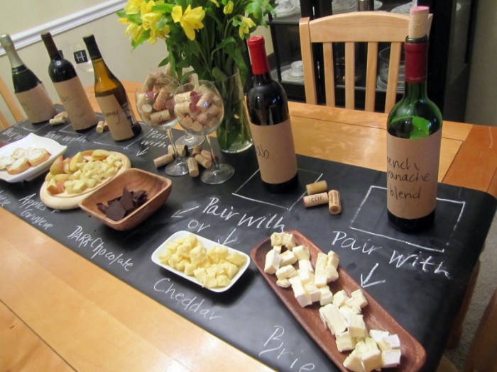 chockolate and apples, different kinds of cheese, and other snacks, near five bottles of wine, 50th birthday themes, wine tasting experience
