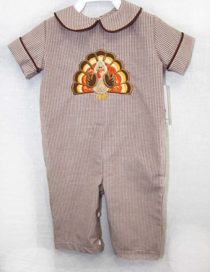 peter pan collar, and short sleeves, on a checkered onesie, in brown and white, embroidered with a turkey cartoon, baby's first thanksgiving outfit, on a whiite background