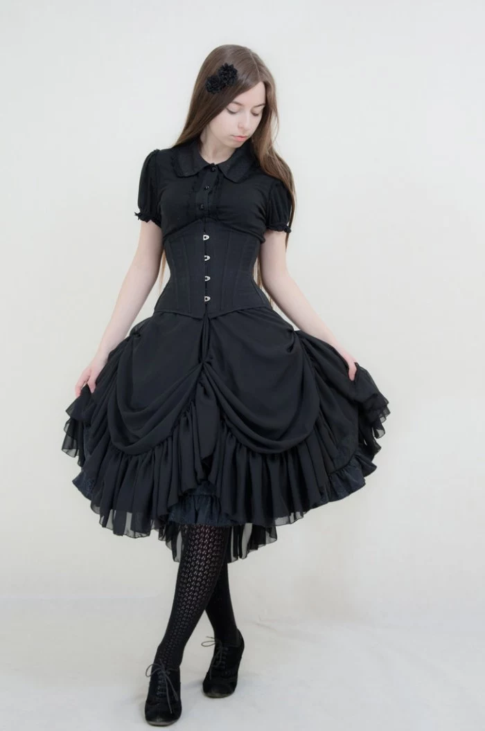 brunette woman with long smooth hair, dressed in a black corset, over a black tiered dress, lolita fashion, black knitted tights
