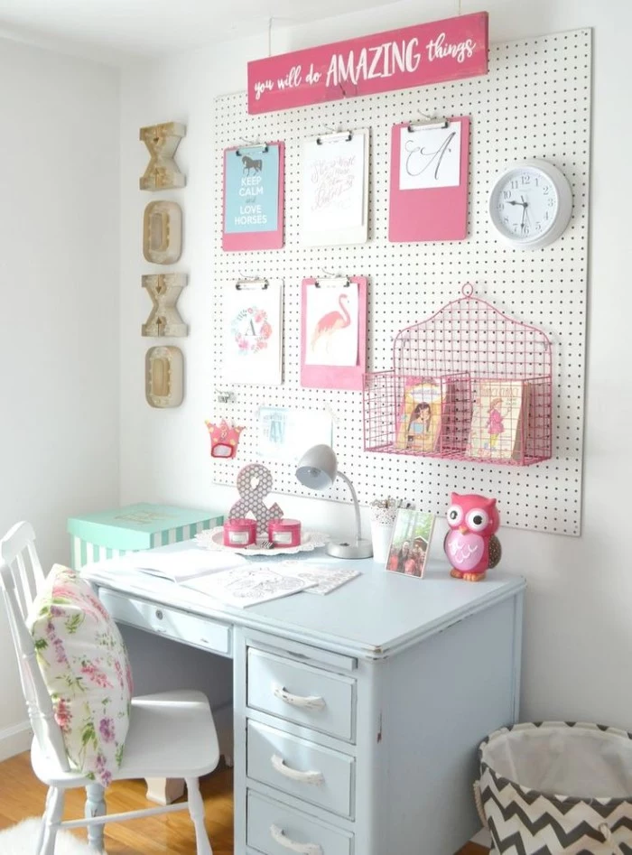 wall organizer in white and pink, on a white wall, near a pale blue retro desk, with a white vintage chair