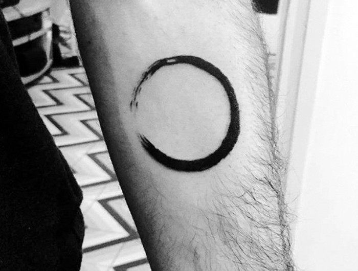 tattoos with deep meaning, japanese calligraphy zen symbol, enso meaning a circle, tattooed in black, on a man's arm, symbolizing the universe, strength and enlightenment