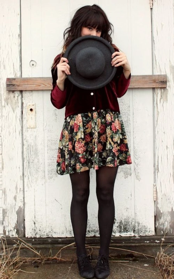 teenage girls thanksgiving outfit, burgundy red velvet cardigan, over a multicolored dress, with a floral pattern, and sheer black tights, black felt hat