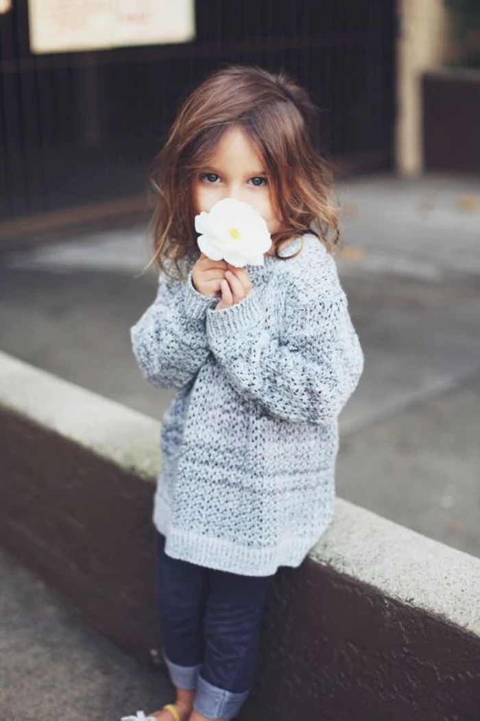 chestnut brown shoulder length hair, on a small child, dressed in an oversized, grey knitted jumper, girls thanksgiving outfit, skinny dark blue jeans