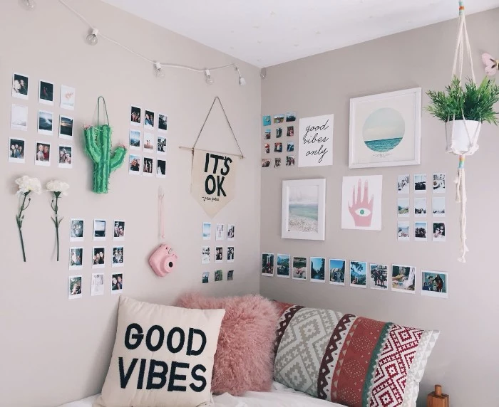 multiple polaroid photos, framed images and flowers, on the beige walls, of a room with a bed, teen bedrooms, three cushions in different colors