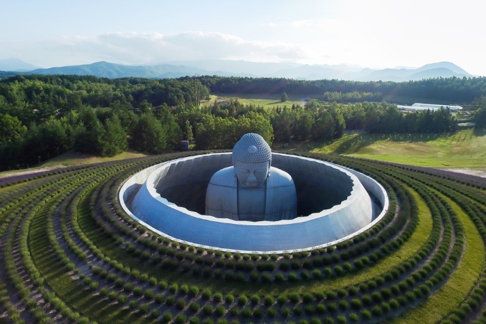 hill of the buddha, in sappporo japan, concrete architecture, a large statue, surrounded by concrete rings, green grass and shrubs