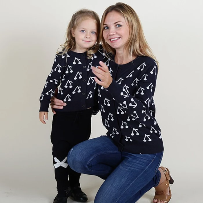 cherry print in white, on navy blue jumpers, worn by a mother and daughter duo, cute thanksgiving outfits, blue jeans and black and white trousers