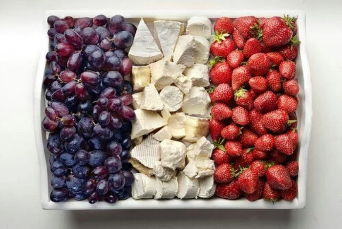 large white rectangular ceramic plate, containing black grapes, cheese and strawberries, 50th birthday party ideas, colorful canape ideas