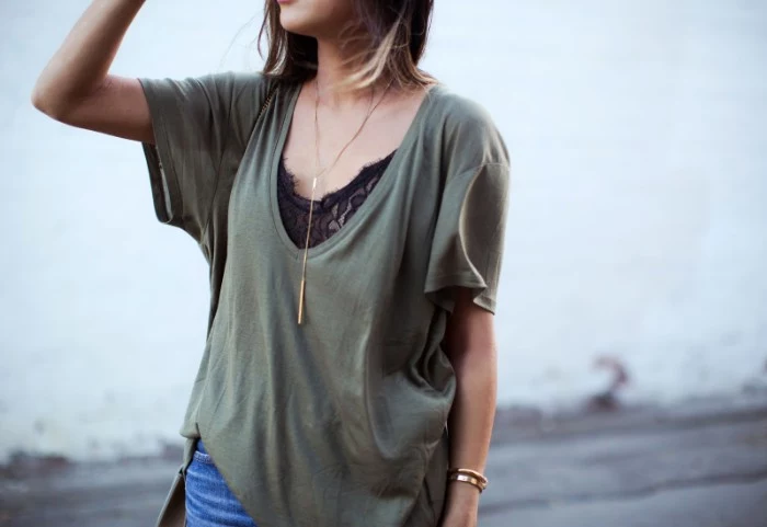 loose grayish-green v-neck t-shirt, over a black lace bralette, what to wear with a bralette, combined with blue jeans, and a long and thin gold necklace