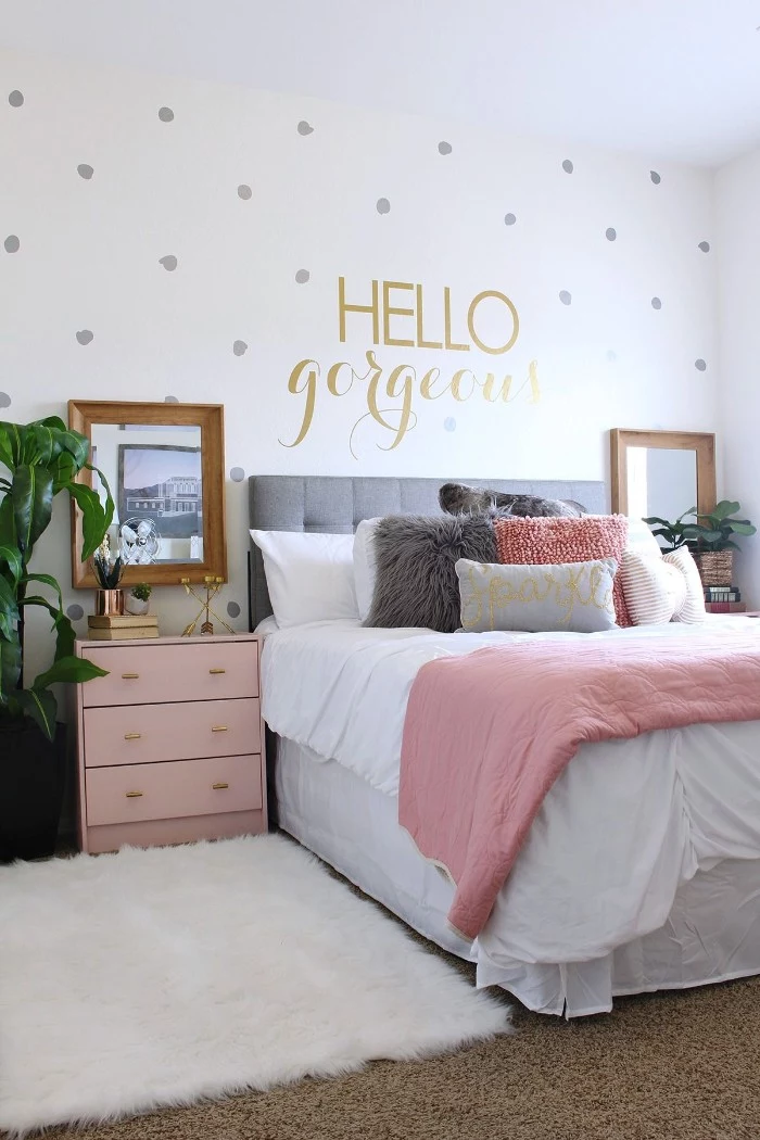 fluffy white rug, and beige carpet, in a room with white walls, decorated with silver dots, and the words hello gorgeous, written in gold, teen bedrooms, bed with several cushions, pink chest of drawers