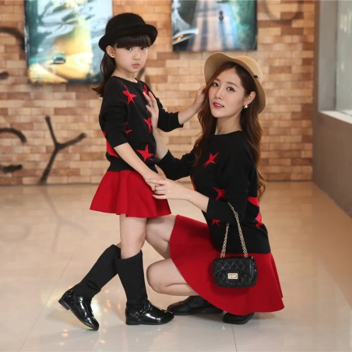 stars in red, on identical black jumpers, worn with red mini skirts, by a mother and a daughter, toddler thanksgiving outfit, coordinated looks