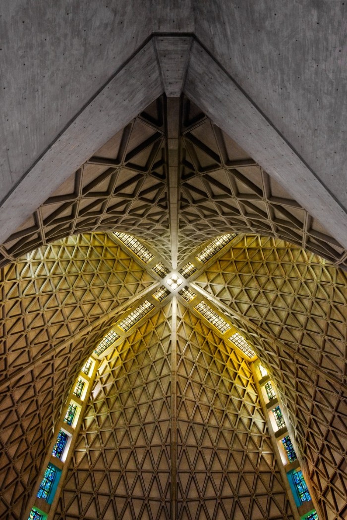 dome of a modern church, made of concrete, and seen from within, with colorful stained windows, brutalism in architecture 