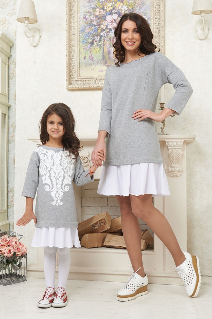 daughter and mother holding hands, dressed in almost identical, cute thanksgiving outfits, long pale grey jumpers, with quarter sleeves, over white mini skirts