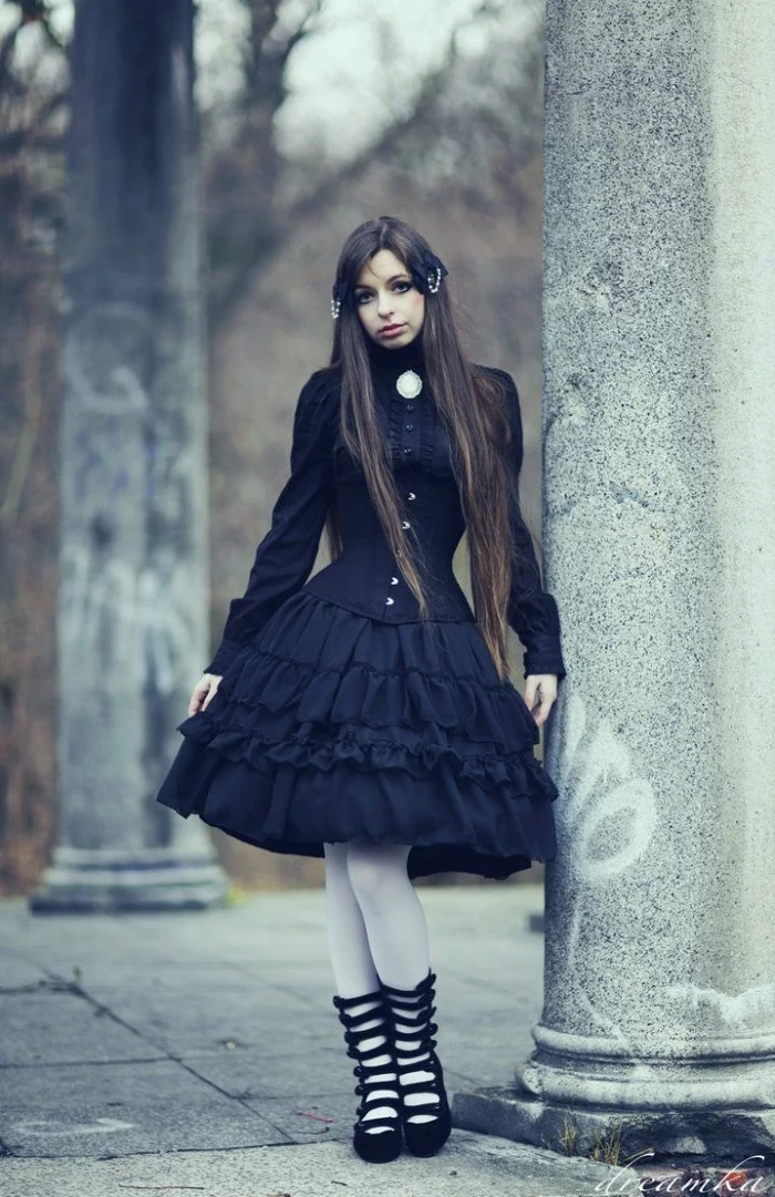 long brunette hair, on a pale girl, wearing a black frilly dress, with a black corset, and white tights, define lolita, black shoes with multiple straps, and a cameo brooch